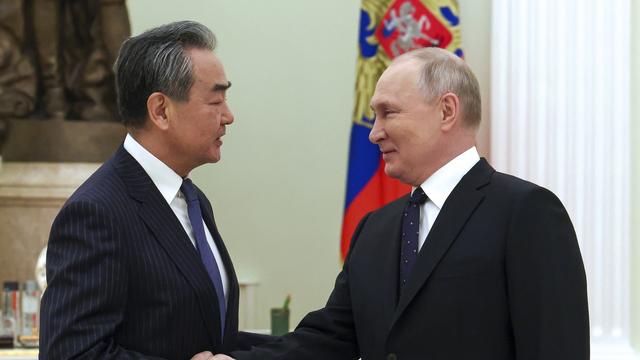 Le président russe Vladimir Poutine salue le chef de la politique étrangère du Parti communiste chinois Wang Yi lors de leur rencontre au Kremlin à Moscou le 22 février 2023. [Keystone - Anton Novoderezhkin, Sputnik, Kremlin Pool Photo via AP]