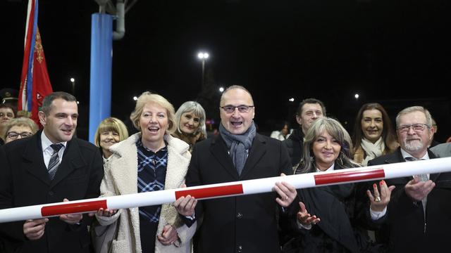 Le ministre croate des affaires étrangères Goran Grlic-Radman soulève une barrière à la frontière, pour marquer l'entrée de la Croatie dans l'espace Schengen. [Keystone - Armin Durgut]