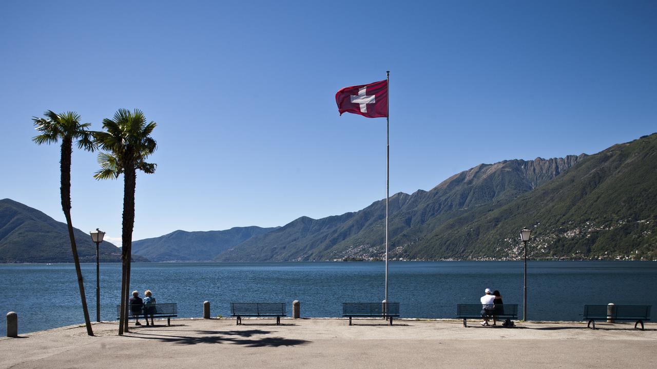 Des touristes se promènent au bord du lac à Ascona, dans le canton du Tessin. [Keystone - Gaetan Bally]