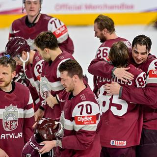 Les joueurs de la Lettonie célèbrent après avoir remporté le match de quart de finale des Championnats du monde de hockey contre la Suède, à Riga, Lettonie, le 25 mai 2023. [AFP - Gints Ivuksans]