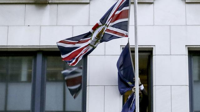 31 janvier 2020. Le Royaume-Uni n'est plus membre de l'Union européenne. Sur cette image, un homme retire le drapeau étoilé de la façade de la représentation britannique auprès des institutions de l'UE à Bruxelles. [Keystone - Olivier Hoslet/AP]