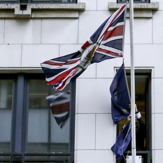 31 janvier 2020. Le Royaume-Uni n'est plus membre de l'Union européenne. Sur cette image, un homme retire le drapeau étoilé de la façade de la représentation britannique auprès des institutions de l'UE à Bruxelles. [Keystone - Olivier Hoslet/AP]