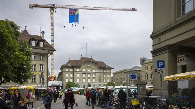 Des militants de Greenpeace se sont suspendus à une grue près du Palais fédéral à Berne. [Keystone - Peter Klaunzer]