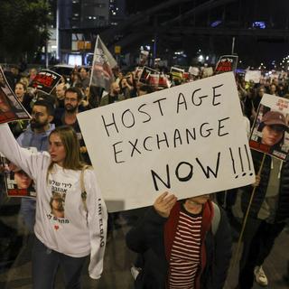 Des familles et des sympathisants des otages détenus par des militants palestiniens depuis l'attaque du 7 octobre ont manifesté devant le ministère israélien de la Défense à Tel Aviv le 15 décembre 2023. [AFP - AHMAD GHARABLI]