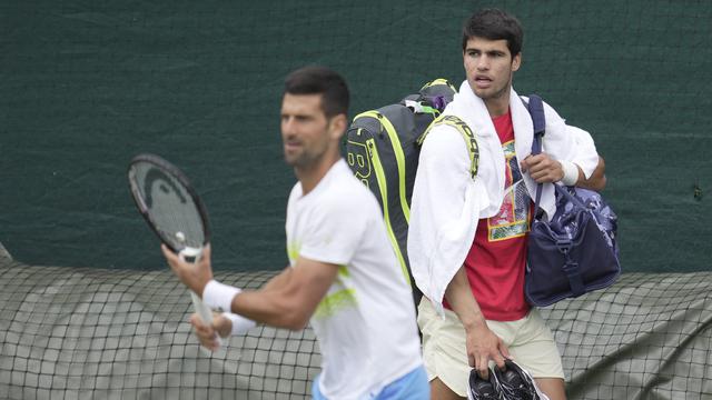 Les joueurs de tennis Novak Djokovic (gauche, Serbie) et Carlos Alcaraz (droite, Espagne) lors d'un entraînement en amont du tournoi anglais de Wimbledon, le 2 juille 2023. [keystone/AP Photo - Kin Cheung]