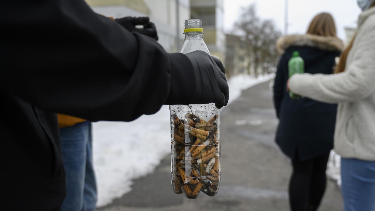 Des élèves ramassent des mégots de cigarettes dans le cadre de l'action "Stop2drop". [Keystone - Leandre Duggan]