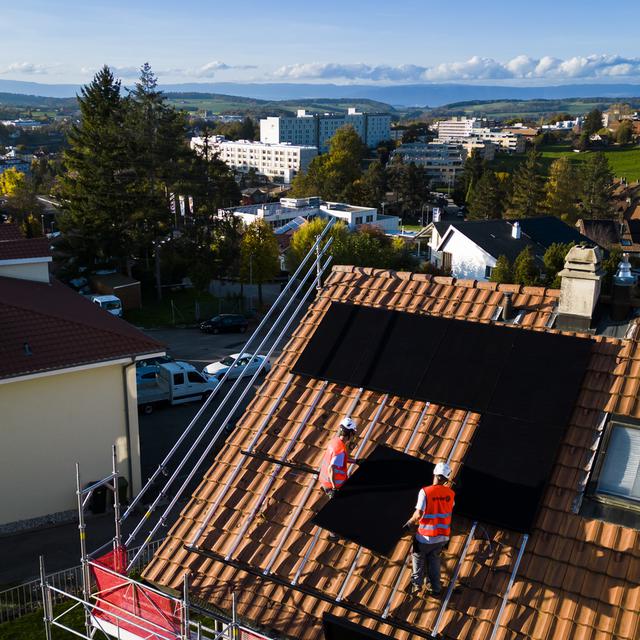 Des panneaux solaires sont installés sur le toit d'une habitation (image d'illustration). [Keystone - Jean-Christophe Bott]