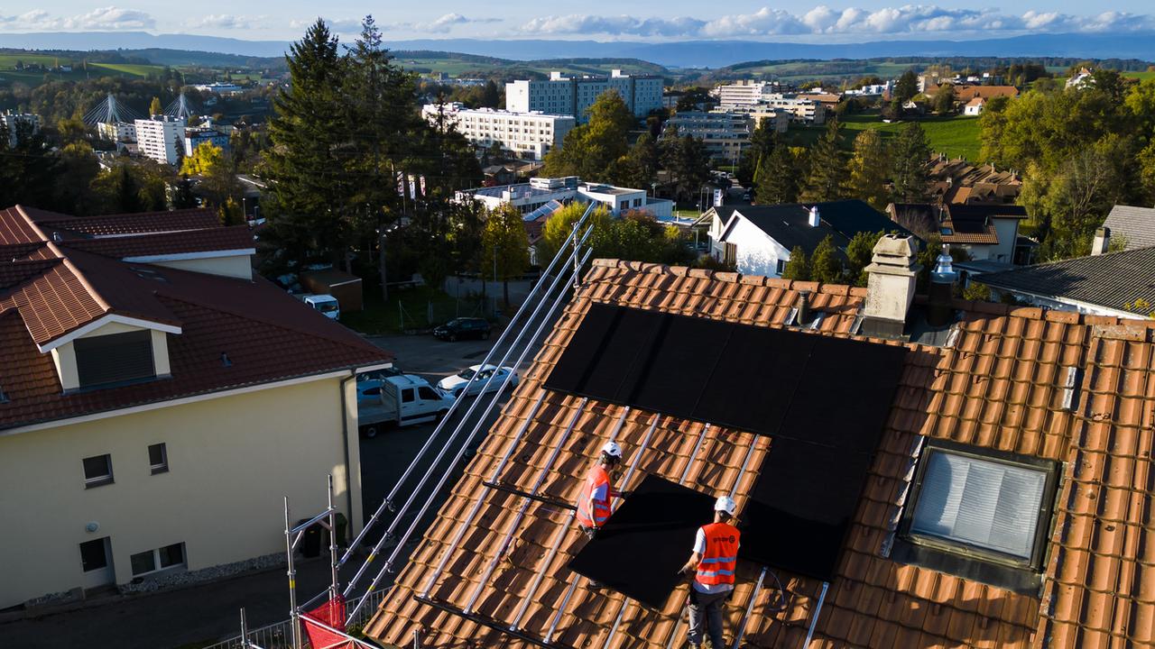 Des panneaux solaires sont installés sur le toit d'une habitation (image d'illustration). [Keystone - Jean-Christophe Bott]