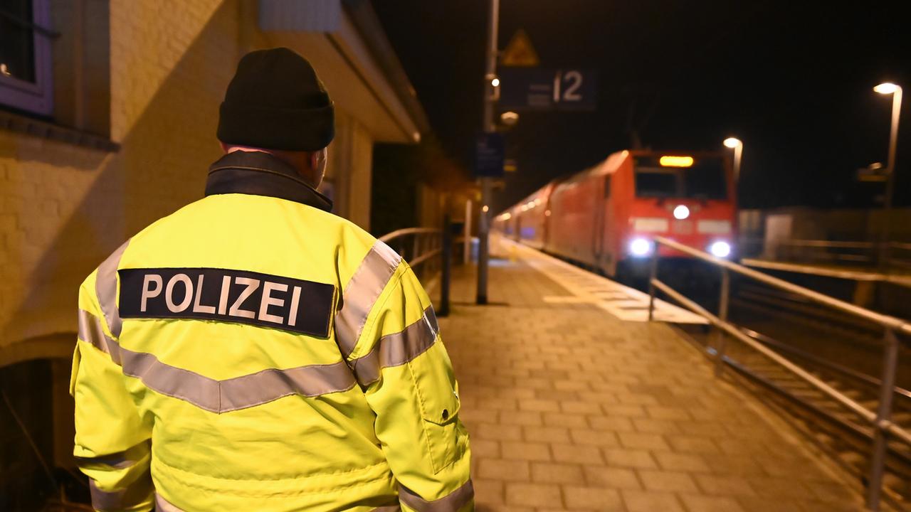 Un policier intervient sur un quai de gare près d'un train régional reliant Kiel à Hambourg, où deux personnes ont été tuées et plusieurs autres blessées lors d'une attaque au couteau, mercredi 25 janvier 2023. [Jonas Walzberg / DPA]