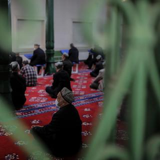 Des hommes de l'ethnie minoritaire Ouïghour prient dans la Mosquée Id Kah, la plus grande mosquée de Chine située dans la ville de Kachgar, région du Xinjiang (Chine). [Keystone/EPA - Wu Hong]