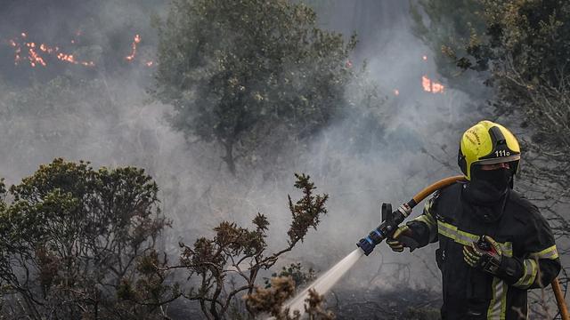 Un pompier se battant contre les flemmes à Alto do Alvide au Portugal. [EPA - Manuel de Almeida]