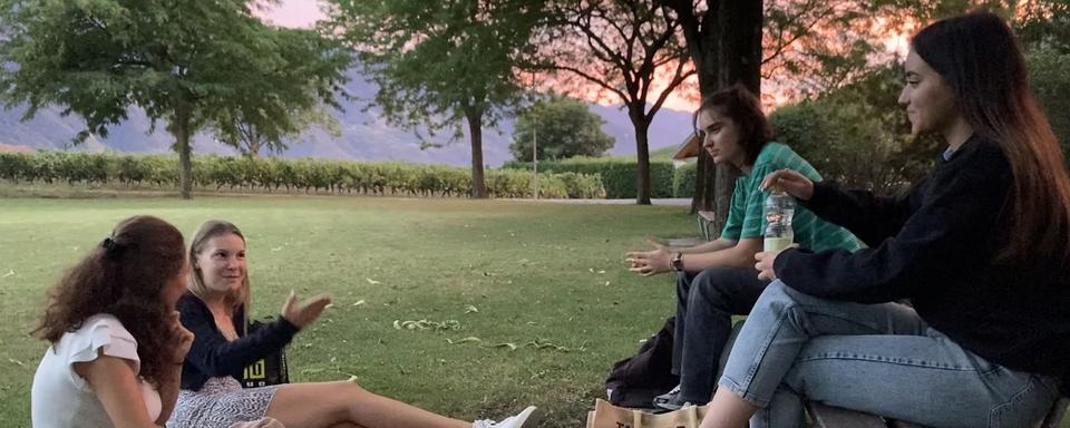 Lydia Russi (à droite en noir) et ses amies lors d’une soirée dans un parc à Sierre. [RTS - Valentin Emery]