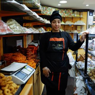 Dans une boulangerie de Paris, une jeune femme vend des pâtisseries préparées spécialement pour le repas de l'iftar en ce mois de ramadan. [AFP - Ameer Alhabi]