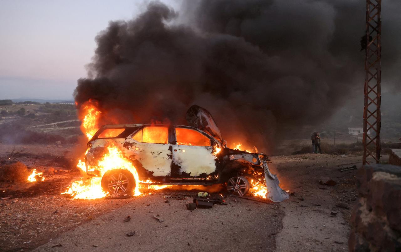 Une voiture brûle sur le site où le vidéo-journaliste de Reuters Issam Abdallah a été tué et six autres personnes ont été blessées vendredi au Liban, près de la frontière avec Israël. [Reuters - Thaier Al-Sudani]