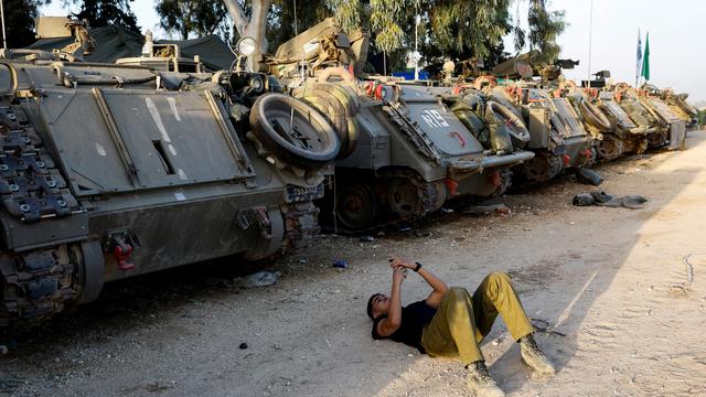 Un soldat israélien attend près de véhicules militaires à la frontière vers Gaza. [Reuters - Amir Cohen]