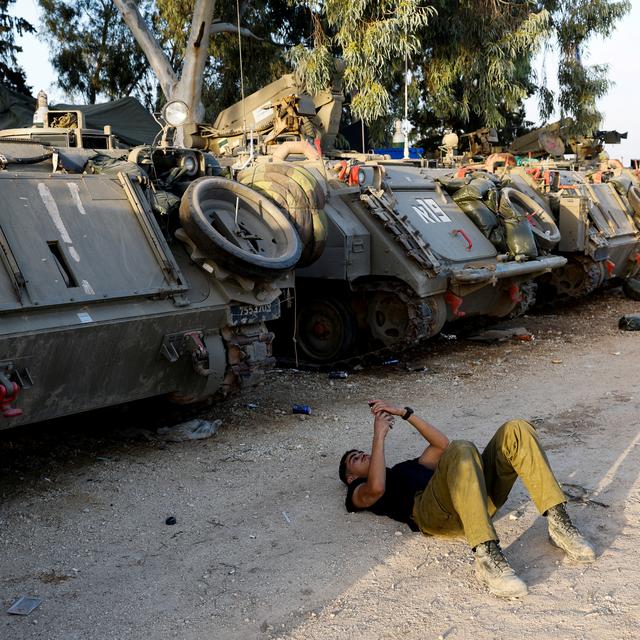 Un soldat israélien attend près de véhicules militaires à la frontière vers Gaza. [Reuters - Amir Cohen]