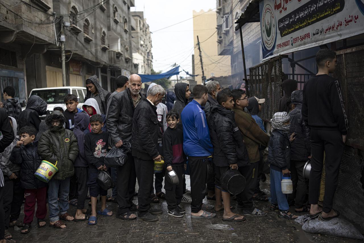 Des Palestiniens font la queue pour une distribution de nourriture à Rafah, dans le sud de la bande de Gaza, le 13 décembre 2023. [KEYSTONE - FATIMA SHBAIR]