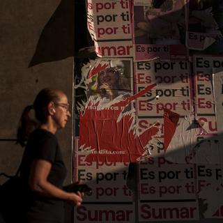 Une femme devant des affiches électorales de la gauche espagnole, juillet 2023 (image d'illustration). [Keystone/AP Photo - Manu Fernandez]