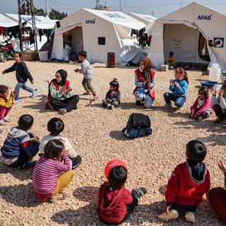 Des enfants jouent dans un camp après le tremblement de terre en Turquie. [Keystone - EPA/Erdem Sahin]