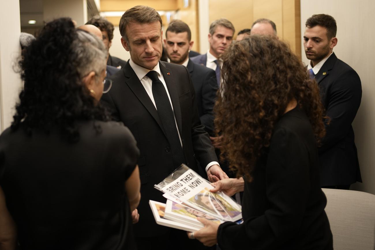 Le président français Emmanuel Macron rencontre des ressortissants franco-israéliens qui ont perdu des proches ainsi que des familles d'otages à l'aéroport Ben Gourion, près de Tel-Aviv, en Israël. [Keystone - Christophe Ena / EPA]