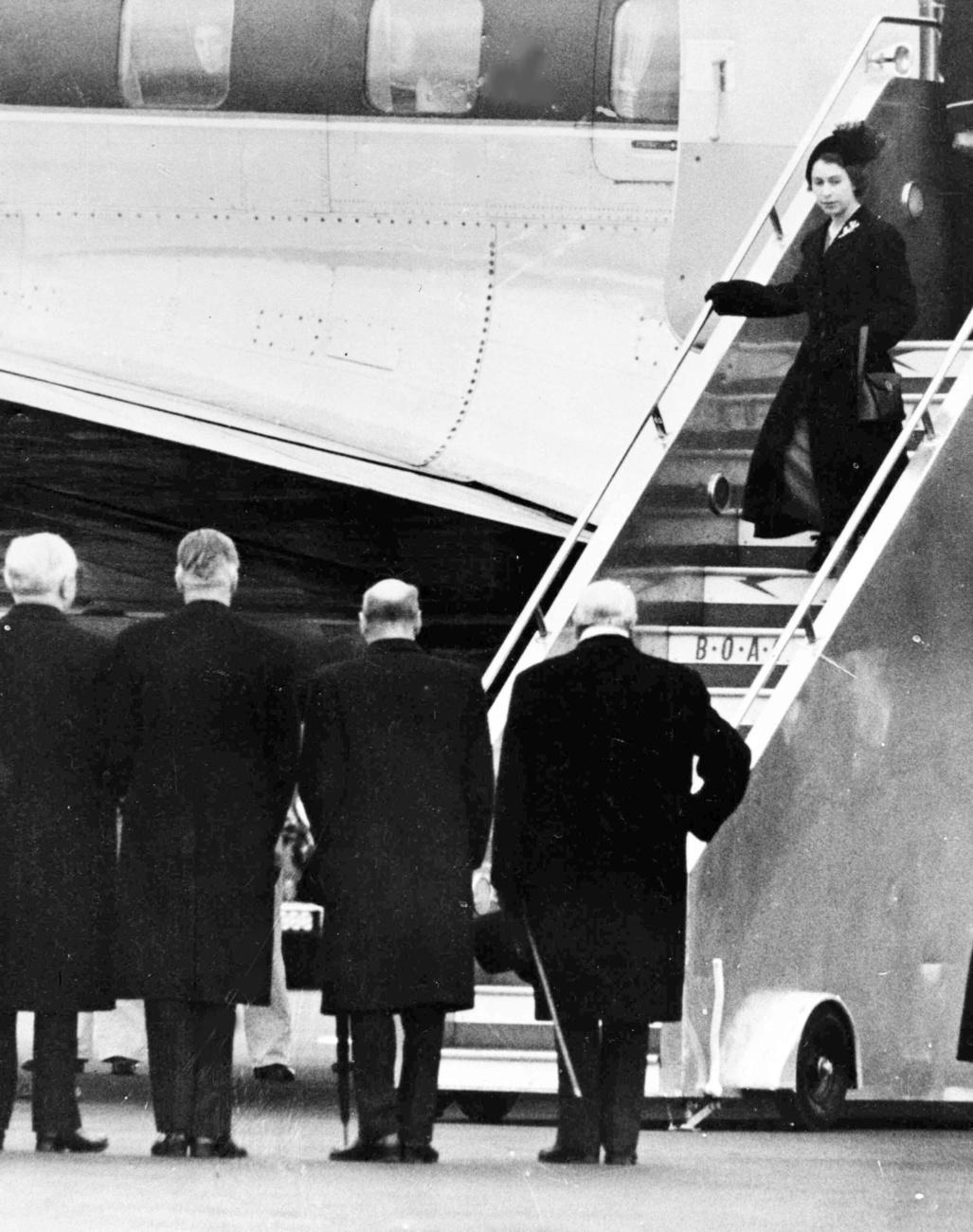 Elizabeth II est accueillie par Winston Churchill, Clemet Attlee, Anthony Eden et Lord Woolton (de droite à gauche) à sa descente d'avion le 7 février 1952, un jour après le décès de son père, le roi George VI. [Keystone/AP Photo]