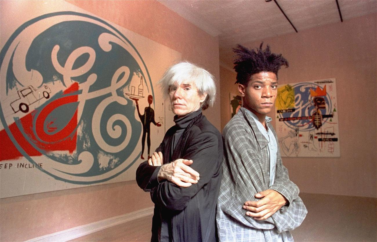 Les deux artistes américains Andy Warhol (à gauche) et Jean-Michel Basquiat lors de leur exposition commune à New York en 1985. [Keystone/Ap Photo - Richard Drew]