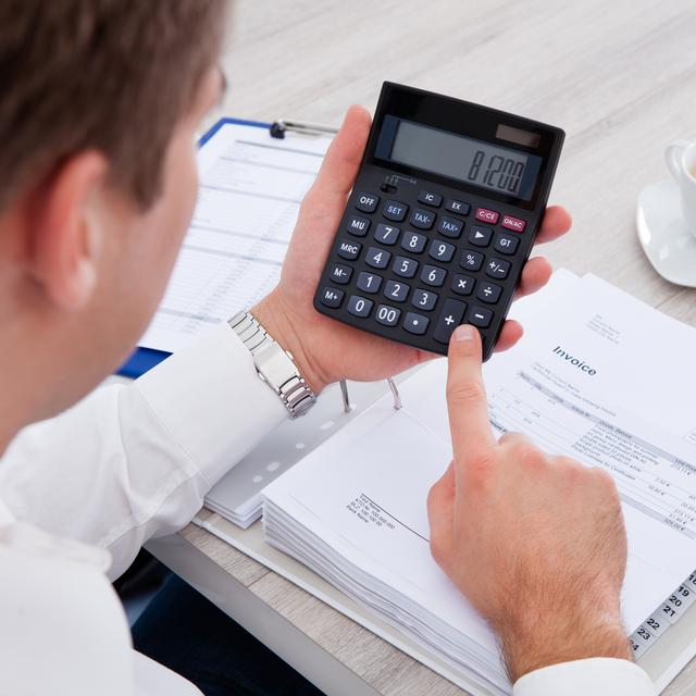 Un homme effectue des calculs avec une calculatrice. [Depositphotos - AndreyPopov]