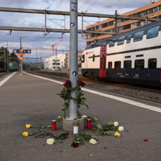Des roses déposées sur le quai n°4 de la gare de Morges, lors d'un rassemblement à la mémoire de Nzoi, tué par balle par un policier en août 2021. [Keystone - Pierre Albouy]