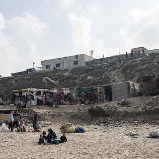 Des Palestiniens sur une plage à Gaza. [Keystone - EPA/Haitham Imad]