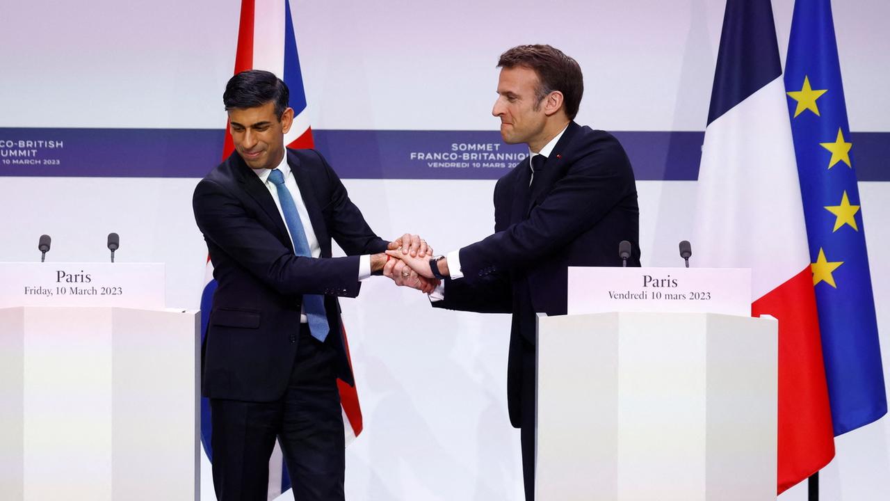 Le président français Emmanuel Macron et le Premier ministre britannique Rishi Sunak se serrent la main après avoir conclu un accord sur l'immigration illégale, au palais de l'Élysée, à Paris, vendredi 10 mars 2023. [Keystone - Gonzalo Fuentes / EPA]