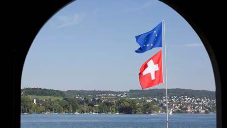 Un drapeau européen et un drapeau suisse flottent dans le vent au bord du lac de Zurich. [Keystone]