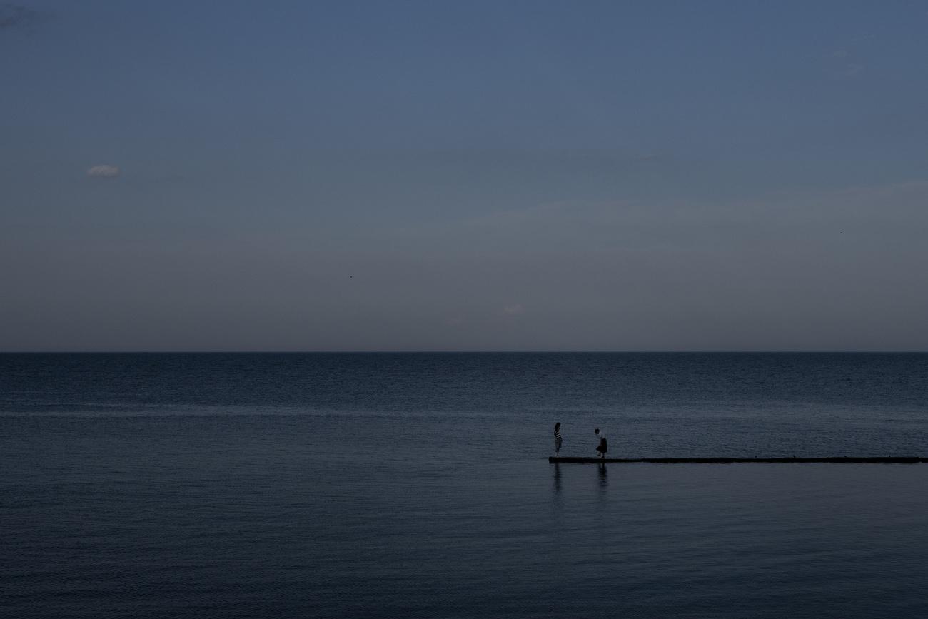 Deux personne se tenant sur une jetée à Odessa. [AP Photo - Jae C. Hong]