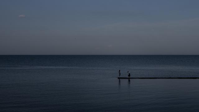 Deux personne se tenant sur une jetée à Odessa. [AP Photo - Jae C. Hong]