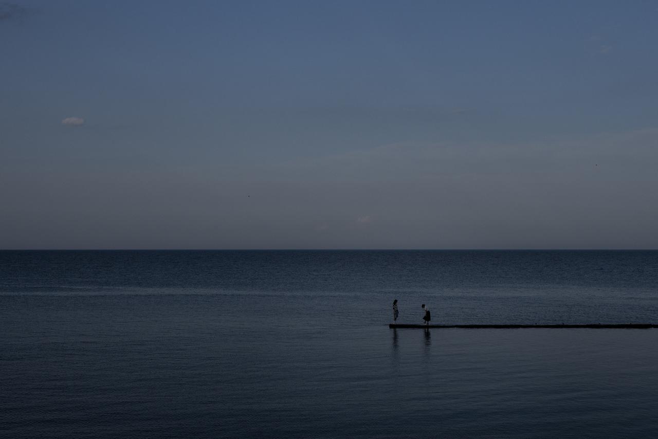 Deux personne se tenant sur une jetée à Odessa. [AP Photo - Jae C. Hong]