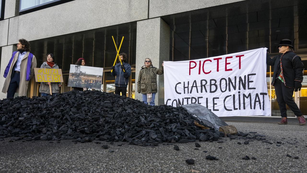 Des avistes du climat ont déversé 250 kilos de charbon devant l'entrée de Pictet à Genève. [Keystone - Martial Trezzini]