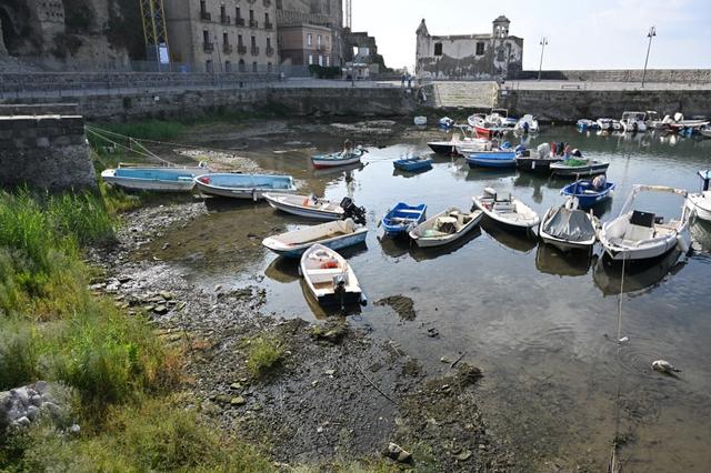 Dans ce port, le niveau de l'eau semble avoir baissé. Les bateaux, les rochers, tout le village, sont en réalité poussés vers le haut par l’énorme quantité de magma et de gaz. [AFP - Alberto Pizzoli]