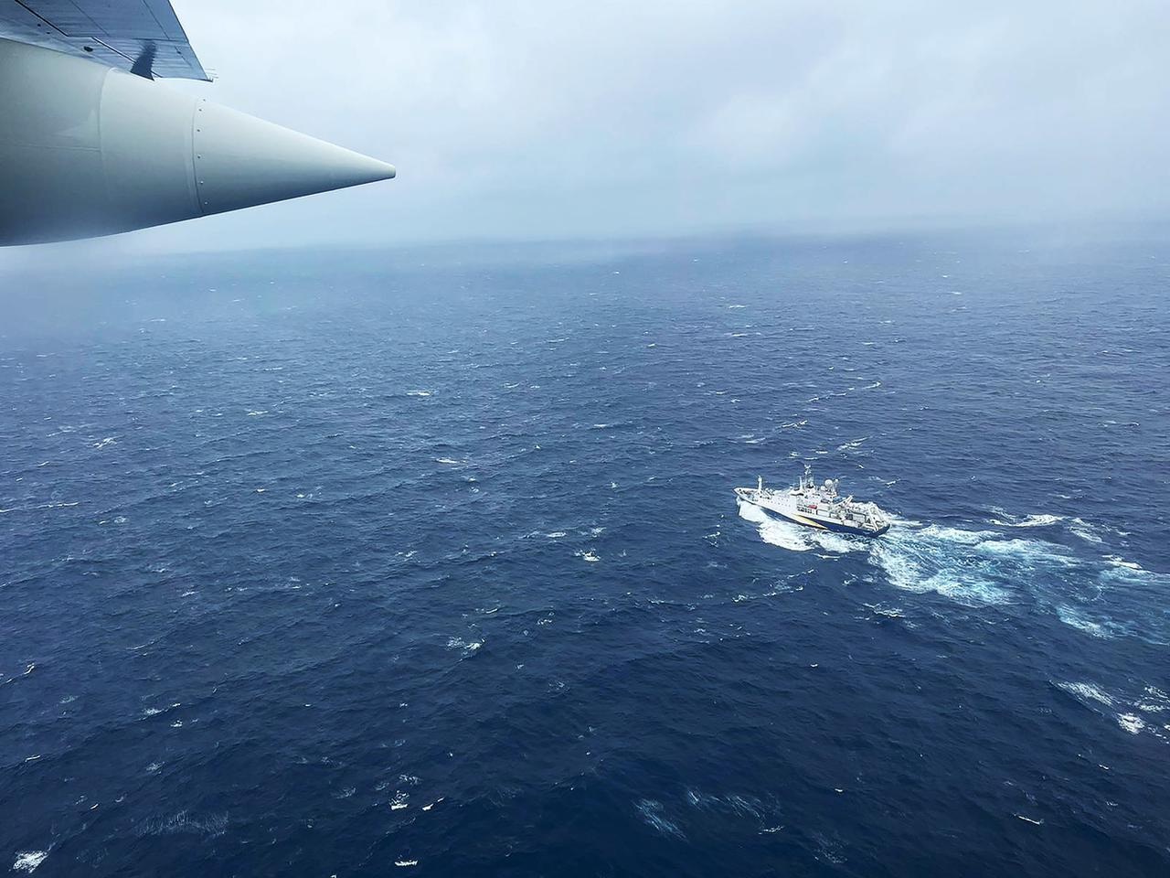 Les autorités américaines et canadiennes ont déployé un important dispositif de recherche. Sur cette image, un avion HC-130 Hercules des garde-côtes américains survole le navire français L'Atalante. [Keystone - U.S. Coast Guard via AP]