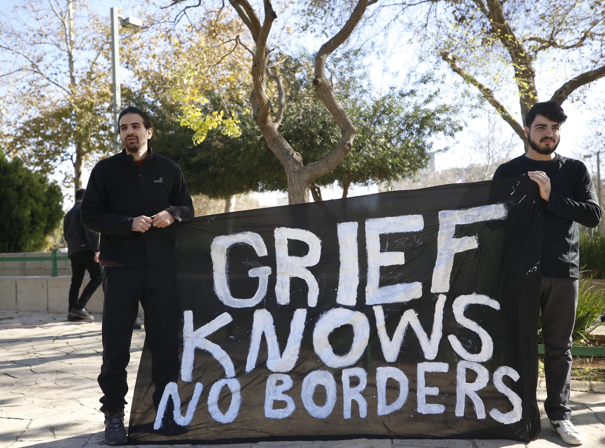 Des militants de gauche israéliens affichent une banderole disant "Le deuil ne connaît pas de frontière" devant l'ambassade américaine à Jérusalem. [AFP - Saeed Qaq]