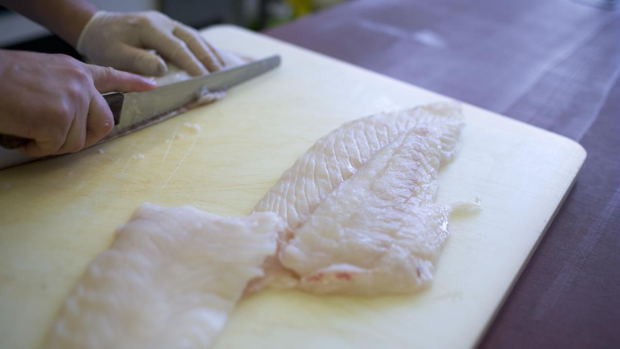 Préparation d'un filet de poisson dans un restaurant suisse en 2009. [Keystone - Gaetan Bally]