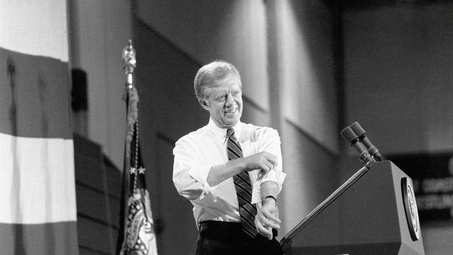 Le président américain Jimmy Carter retrousse ses manches pendant son discours de campagne, lors d'une réunion publique à l'Université Hofstra à Hempstead, le 16 octobre 1980. [KEYSTONE - WILSON]