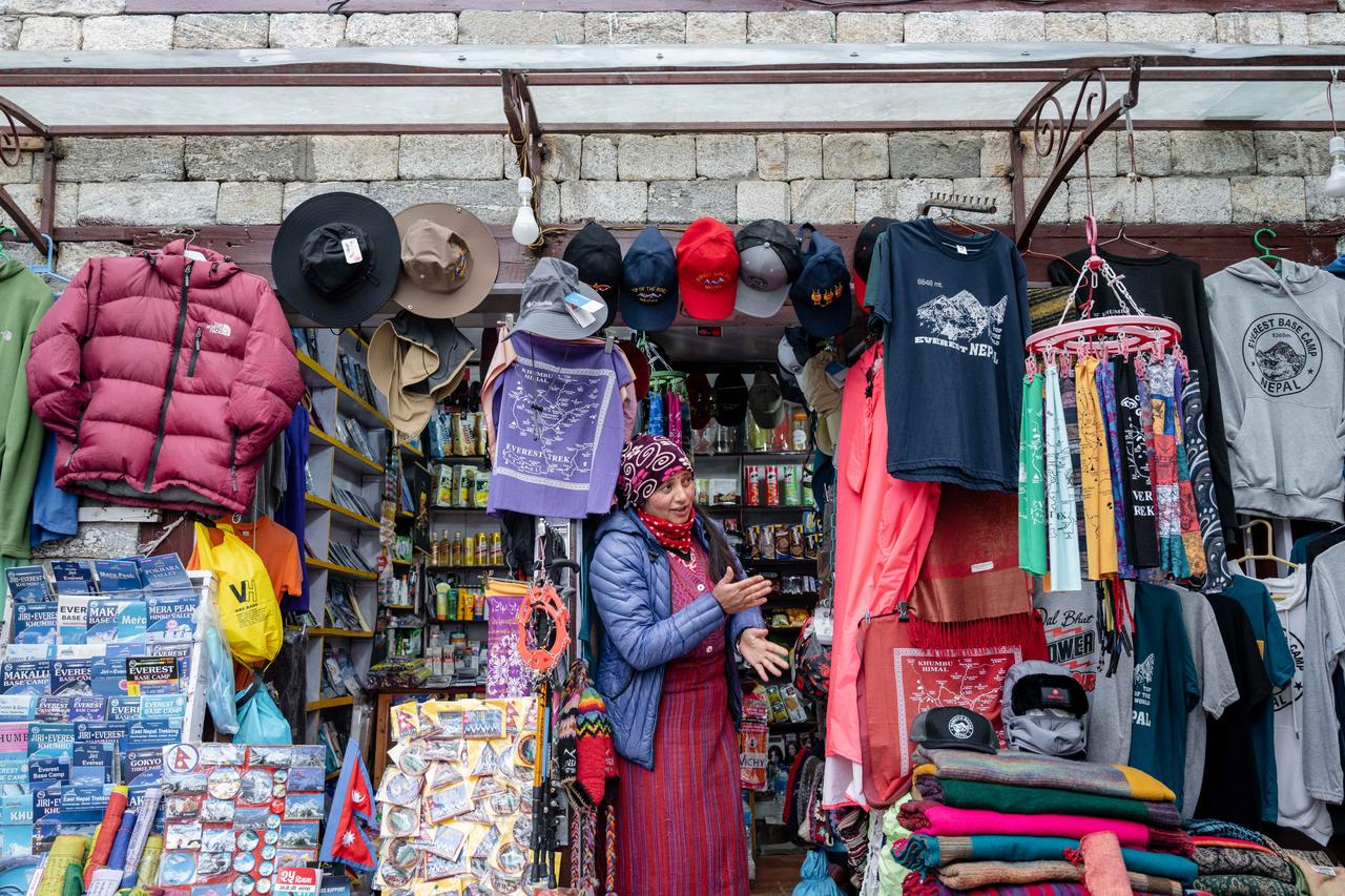 Une commerçante à l'entrée de son magasin de souvenirs dans la ville de Namche Bazaar, au Népal, souvent surnommée la porte de l'Everest. [AFP - Robic Upadhayay]