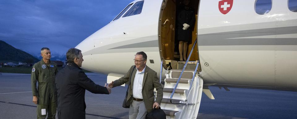 Le conseiller fédéral suisse Ignazio Cassis, à gauche, accueille Christian Winter, ambassadeur suisse du Soudan, à l'aéroport de Berne-Belp à Belp, en Suisse, le mardi 25 avril 2023. [Keystone - Peter Schneider]