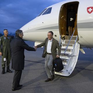 Le conseiller fédéral suisse Ignazio Cassis, à gauche, accueille Christian Winter, ambassadeur suisse du Soudan, à l'aéroport de Berne-Belp à Belp, en Suisse, le mardi 25 avril 2023. [Keystone - Peter Schneider]