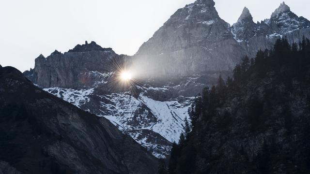 Le soleil brille dans le trou du Martinsloch à Elm. [Keystone - Gian Ehrenzeller]