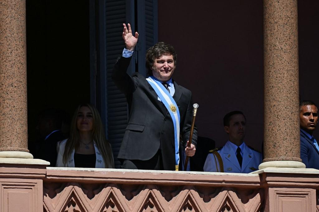 Le nouveau président argentin Javier Milei salue la foule depuis le balcon du palais gouvernemental Casa Rosada lors de sa journée d'investiture à Buenos Aires, le 10 décembre 2023. [AFP - Pablo Porciuncula]