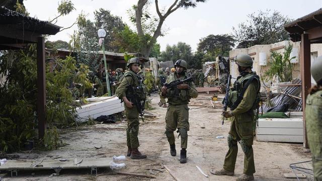 Des soldats israéliens dans le kibboutz Kfar Azza après l'attaque du 7 octobre. [Keystone]