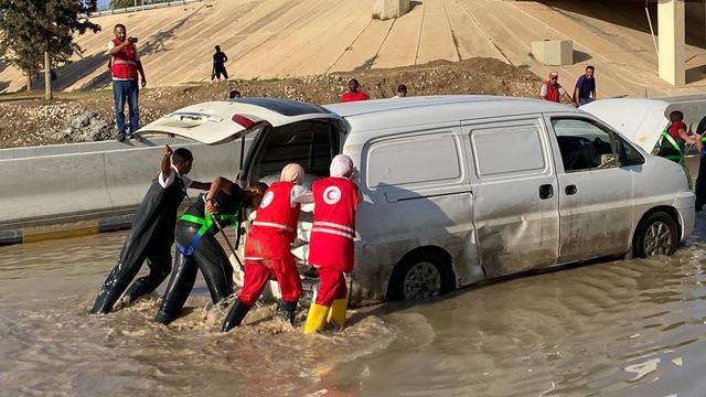 Des volontaires du Croissant-Rouge libyen dans une rue inondée, le 11 août. [Keystone - EPA]