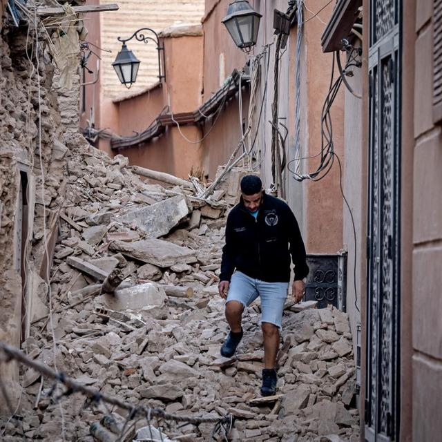 Un habitant de Marrakech se fraye un chemin dans les décombres après le puissant séisme qui a secoué le Maroc le 8 septembre 2023. [AFP - Fadel Senna]