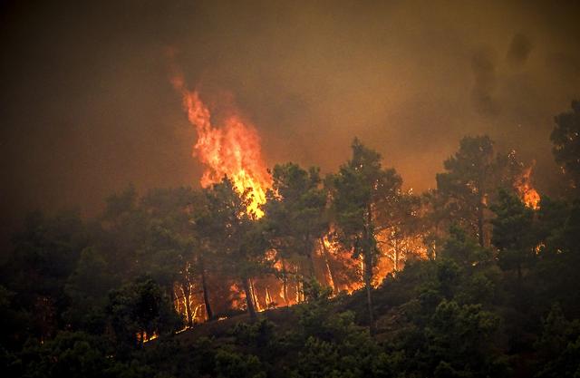 Cinq hélicoptères et 173 pompiers sont engagés pour combattre le feu à Rhodes. [Keystone - Argyris Mantikos/Eurokinissi via AP]