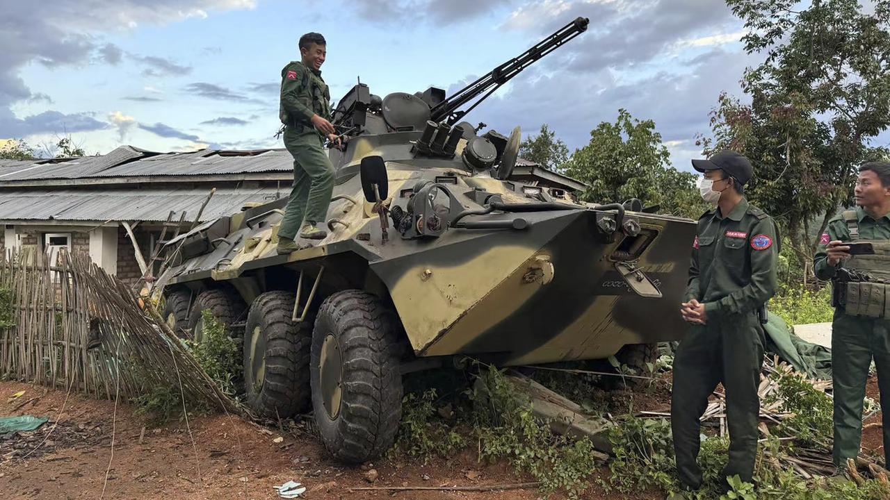 Des membres d'un groupe de forces armées ethniques, l'une des trois milices de l’Alliance de la fraternité, vérifient un véhicule blindé de l'armée que le groupe aurait saisi dans l'État de Shan, en Birmanie, le 24 novembre 2023. [Keystone - The Kokang online media via AP]